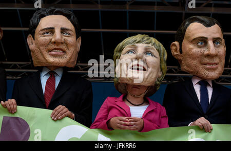 Hamburg, Deutschland. 2. Juli 2017. Teilnehmer an den Protesten gegen den G20-Gipfel im Bild stehend auf der Bühne tragen mit dem Bildnis der kanadische Premierminister Trudeau, Bundeskanzlerin Angela Merkel und der französische Präsident Macron in Hamburg, Deutschland, 2. Juli 2017 Masken Welle. Foto: Axel Heimken/Dpa/Alamy Live News Stockfoto