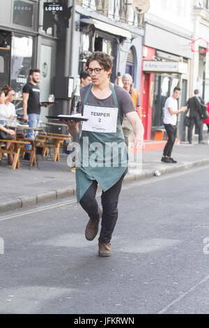 Soho, London. 2. Juli 2017. Londoner Restaurantpersonal sprint durch die Straßen von Soho mit einem Tablett in der Hand, beladen mit einer Serviette, eine halbe Flasche Champagner und einem Sektglas, Beschaffung von Mitteln für neue Wohltätigkeitsorganisation der Kellner Unterstützungskasse für angeschlagene Kellner Credit: Amer Ghazzal/Alamy Live-Nachrichten Stockfoto