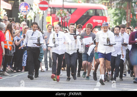 Soho, London. 2. Juli 2017. Londoner Restaurantpersonal sprint durch die Straßen von Soho mit einem Tablett in der Hand, beladen mit einer Serviette, eine halbe Flasche Champagner und einem Sektglas, Beschaffung von Mitteln für neue Wohltätigkeitsorganisation der Kellner Unterstützungskasse für angeschlagene Kellner Credit: Amer Ghazzal/Alamy Live-Nachrichten Stockfoto