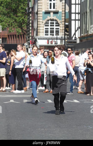 Soho, London. 2. Juli 2017. Londoner Restaurantpersonal sprint durch die Straßen von Soho mit einem Tablett in der Hand, beladen mit einer Serviette, eine halbe Flasche Champagner und einem Sektglas, Beschaffung von Mitteln für neue Wohltätigkeitsorganisation der Kellner Unterstützungskasse für angeschlagene Kellner Credit: Amer Ghazzal/Alamy Live-Nachrichten Stockfoto