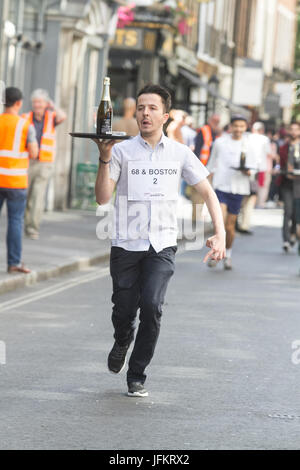 Soho, London. 2. Juli 2017. Londoner Restaurantpersonal sprint durch die Straßen von Soho mit einem Tablett in der Hand, beladen mit einer Serviette, eine halbe Flasche Champagner und einem Sektglas, Beschaffung von Mitteln für neue Wohltätigkeitsorganisation der Kellner Unterstützungskasse für angeschlagene Kellner Credit: Amer Ghazzal/Alamy Live-Nachrichten Stockfoto