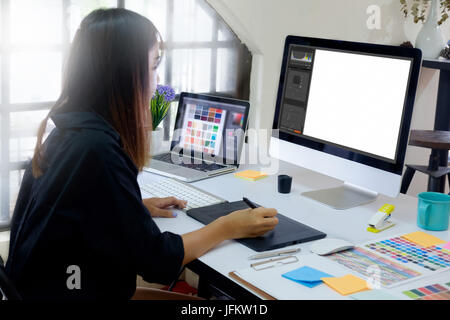 Junge Fotografen und Grafiker bei der Arbeit im Büro.  Leerer Bildschirm Monitor für Grafik-display Montage. Stockfoto