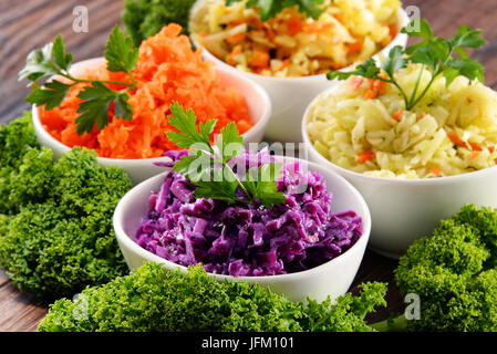 Komposition mit vier Gemüsesalat Schüsseln auf Holztisch. Stockfoto