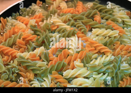 Dreifarben spiralförmigen Nudeln (Fusilli) wird in einer Pfanne gekocht Stockfoto