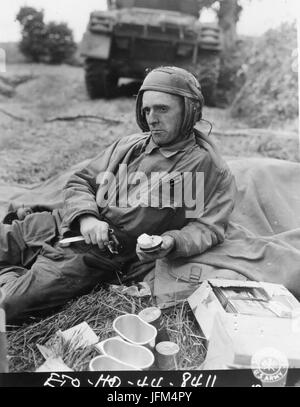 PFC Jerry C. Coleman, Assistent Fahrer eines Panzers befestigt, eine gepanzerte Einheit in Frankreich, nimmt sich Zeit, während einer Pause in der Aktion zu seinem K-Rationen zu essen. Juli 1944. Stockfoto