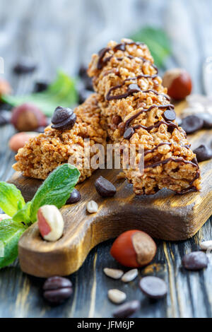 Müsliriegel mit Schokolade und Nüsse auf ein Holzbrett. Stockfoto
