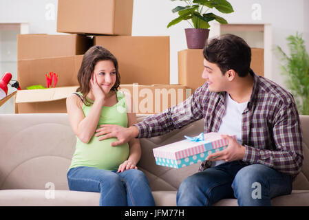 Junges Paar von Mann und schwangere Frau mit Geschenkbox Stockfoto