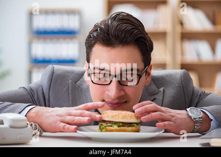 Hungrige lustige Geschäftsmann Essen Junk-Food-sandwich Stockfoto