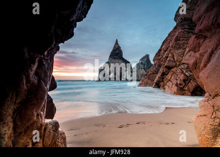 Die Farben des Sonnenuntergangs über dem Meer, umgeben von Klippen vor Dämmerung Praia da Ursa Cabo da Roca Colares Sintra Portugal Europa Stockfoto