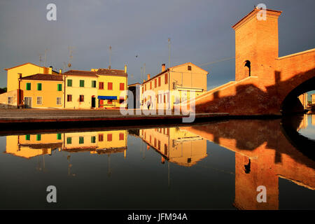 Ansicht von Comacchio bei Sonnenaufgang, mit Häusern spiegelt sich in den Kanal, Bezirk Ferrara, Emilia Romagna, Italien Stockfoto