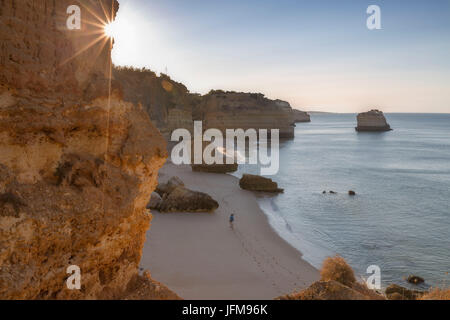 Erste Sonnenstrahlen auf den Klippen und türkisfarbenem Wasser am Praia da Marinha Caramujeira Lagoa Gemeinde Algarve Portugal Europa Stockfoto