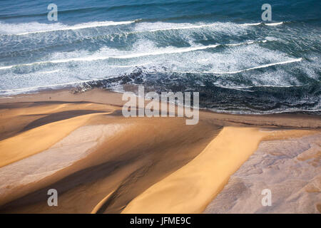 Luftaufnahme von Wellen des Atlantischen Ozeans krachte gegen die Sanddünen der Namib-Wüste Namibia Südliches Afrika Stockfoto