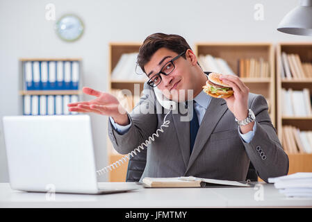 Hungrige lustige Geschäftsmann Essen Junk-Food-sandwich Stockfoto