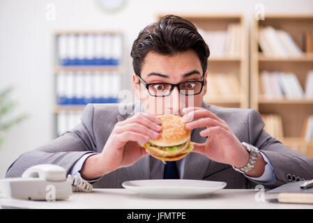 Hungrige lustige Geschäftsmann Essen Junk-Food-sandwich Stockfoto