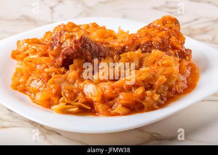 Kohl in weiße Platte mit geräuchertem Schweinefleisch serviert Rippen gekocht. Stockfoto