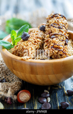 Müsli-riegel mit Schokolade und Haselnüsse in eine hölzerne Schüssel. Stockfoto