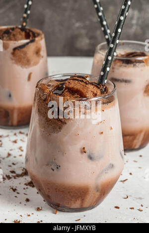 Sommer-Erfrischung Getränke. Geeiste Schokolade Kakao gekühlt. Mit Kugel Schokoladeneis, Schokoladenpulver und Eis. In Gläsern, mit Rohren für Getränke Stockfoto