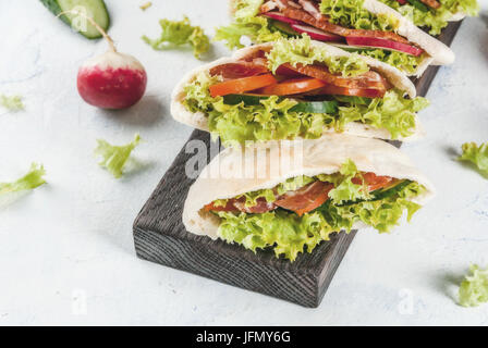 Snack. Speisen zum mitnehmen, Straße Fast-Food. Pita Brot Sandwich mit frischem Gemüse Salat, Gurken, Tomaten, Radieschen, Rindfleisch. Auf einem hellen Beton ta Stockfoto