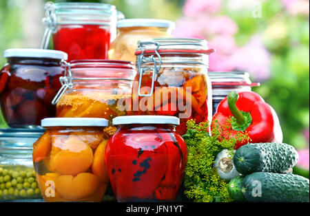 Gläser von eingelegtem Gemüse und Obst im Garten Stockfoto