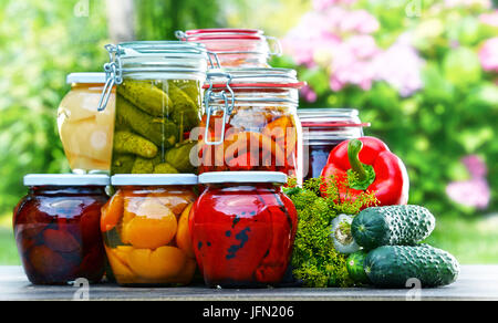Gläser von eingelegtem Gemüse und Obst im Garten Stockfoto