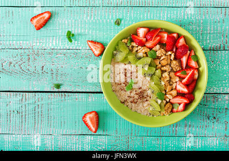 Schmackhafte und gesunde Haferflocken Brei mit Beeren, Nüssen und Flachs Samen. Gesundes Frühstück. Fitness Nahrung. Die richtige Ernährung. Flach zu legen. Ansicht von oben Stockfoto