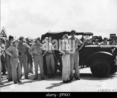 General Carl Spaatz und Personal, zusammen mit Konteradmiral W. R. Purnell und Brigadegeneral Thomas F. Farrell, erwarten die Offiziere und Crew von "Enola Gay" nach der ersten atomaren Bomben auf Hiroshima, Japan. Tinian, 6. August 1945 Stockfoto