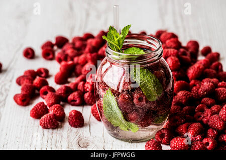 Detox Wasser mit Rasberry auf weißem Hintergrund aus Holz. Gesunde Getränke Stockfoto