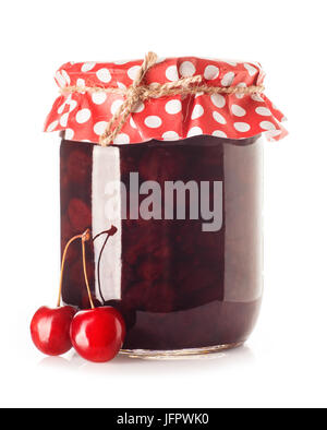 Kirschmarmelade. Glasglas Kirschmarmelade und frischen Kirschen in der Nähe von isoliert auf weißem Hintergrund. Konservierten Früchten. Hausgemachter Marmelade im Glas mit Papier überzogen Stockfoto