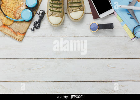 Ansicht von oben Zubehör Konzept zu reisen. Weiße Handy und Kopfhörer auf hölzernen background.essentials Artikel für Reise-Flugzeug, Karte, Pass, Armbanduhr, sho Stockfoto