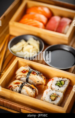 Sushi-Sashimi und Sushi Rolls Set serviert auf Bambus-Tablett Stockfoto