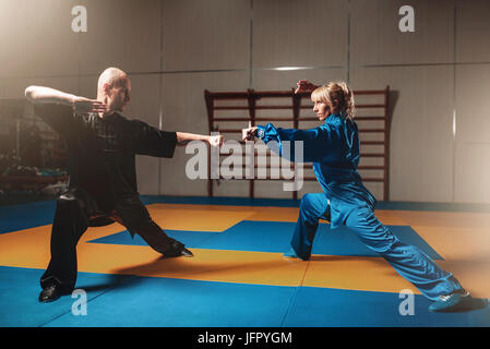 Männliche und weibliche Wushu-Kämpfer Übungen indoor, Martial-Arts. Sparring-Partner in Aktion Stockfoto