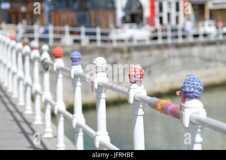 Gestrickte Abdeckungen am Geländer auf Ramsgate Hafenmauer Stockfoto