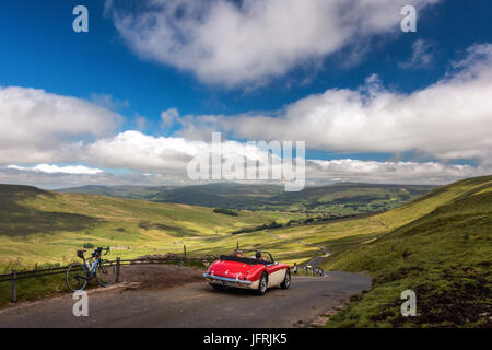 Ansichten von oben der Flotte Moos mit Fahrrad & rot Austin Healey 3000 Straßenfahrzeug - berühmte Radfahren Hügel klettern & Landschaft fahren, Hawes, Yorkshire Dales, UK Stockfoto