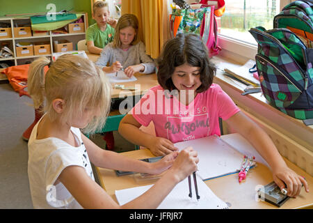 Kinder im Grundschulalter arbeiten mit ihren Kompasse Stockfoto