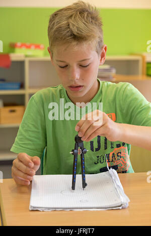 Junge in der Grundschule arbeiten mit seinem Zirkel Stockfoto