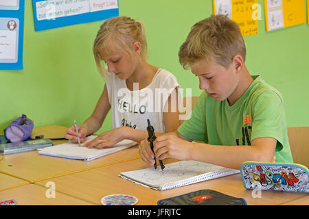 Schülerinnen und Schüler in der Grundschule, arbeiten mit ihren Kompasse Stockfoto
