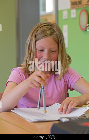 Mädchen in der Grundschule arbeiten mit ihrem Kompasse Stockfoto