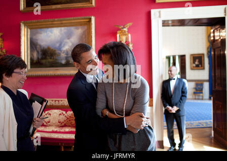 Präsident Barack Obama umarmt First Lady Michelle Obama im Red Room während Senior Advisor Valerie Jarrett Lächeln vor der nationalen Zeitung Publishers Association (NNPA) Rezeption 20.03.09.  Offiziellen White House Photo by Pete Souza Stockfoto