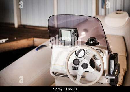 Kleines Motorboot Lenkrad, Controp Panel und Navigation. Boot im Wasser Garage geparkt. Stockfoto