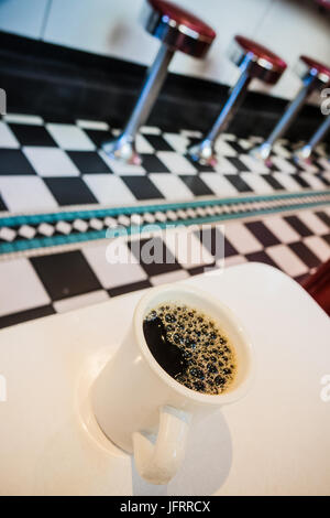 Detail einer Kaffeetasse und Zähler Hocker In einem Retro-USA-Diner Stockfoto