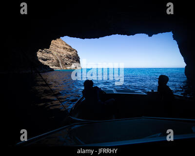 Blick vom Meereshöhle mit Silhouette des 10 Jahre alten Jungen auf Boot Napali Küste, Kauai, Hawaii, USA, sonnigen Sommertag Stockfoto