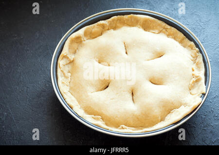 Kochen Kuchen. Ungebackene Mürbeteig Kuchen (Teig, Füllung) in Auflaufform, Vorbereitung zum Backen. Rohe Torte, bereit zum Backen, Kochen Prozess. Stockfoto