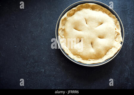 Kochen Kuchen. Ungebackene Mürbeteig Kuchen (Teig, Füllung) in Auflaufform, Vorbereitung zum Backen. Rohe Torte, bereit zum Backen, Kochen Prozess. Stockfoto