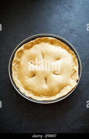 Kochen Kuchen. Ungebackene Mürbeteig Kuchen (Teig, Füllung) in Auflaufform, Vorbereitung zum Backen. Rohe Torte, bereit zum Backen, Kochen Prozess. Stockfoto