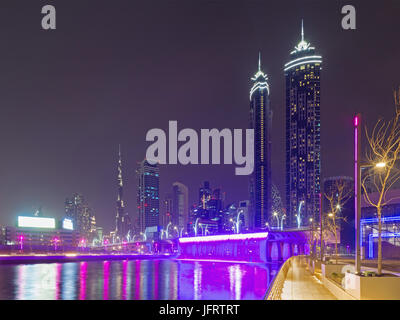 Dubai - die nächtliche Skyline über den Kanal und der Innenstadt mit dem Wasserfall auf der Brücke. Stockfoto