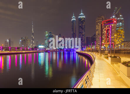 Dubai - die nächtliche Skyline über den Kanal und der Innenstadt mit dem Wasserfall auf der Brücke. Stockfoto