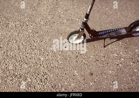 Scooter-Ständer mit Stöpsel auf dem grauen Asphalt ohne Menschen. Stockfoto