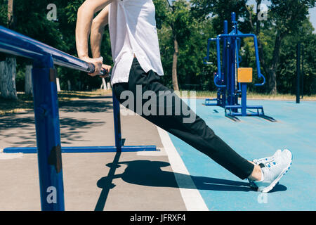 Bild der Frau in Sporthose und T-shirt beschnitten Trizeps-Übungen auf Sport im freien Feld im Sommer. Konzept eines gesunden Lebensstils. Stockfoto