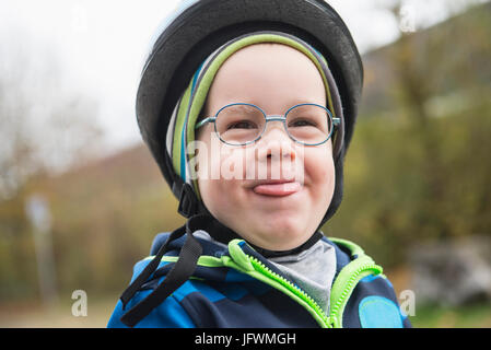 Verspielte junge im Fahrradhelm Zunge aus Mund Nahaufnahme Stockfoto