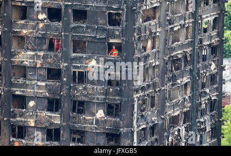 Such- und Rettungsteams durchsuchen die verkohlten Überreste des Turmes Grenfell in Latimer Road Stockfoto